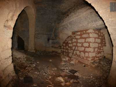 Camminiamo su un tappeto di detriti, avvistando un muro bianco e rossiccio che sembra essere stato realizzato in epoca recente